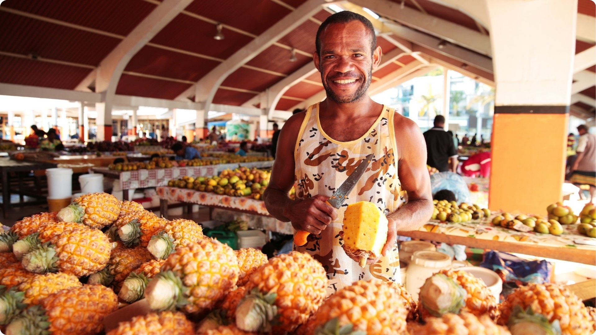 A market vendor selling freshly cut pineapple