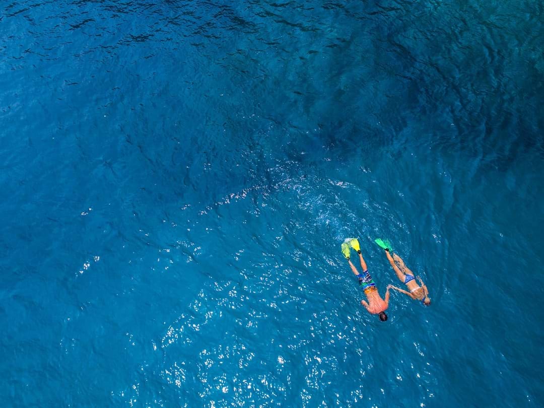 A couple snorkelling in clear blue water in Santo
